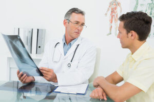 Male doctor explaining lungs x-ray to patient in the medical office